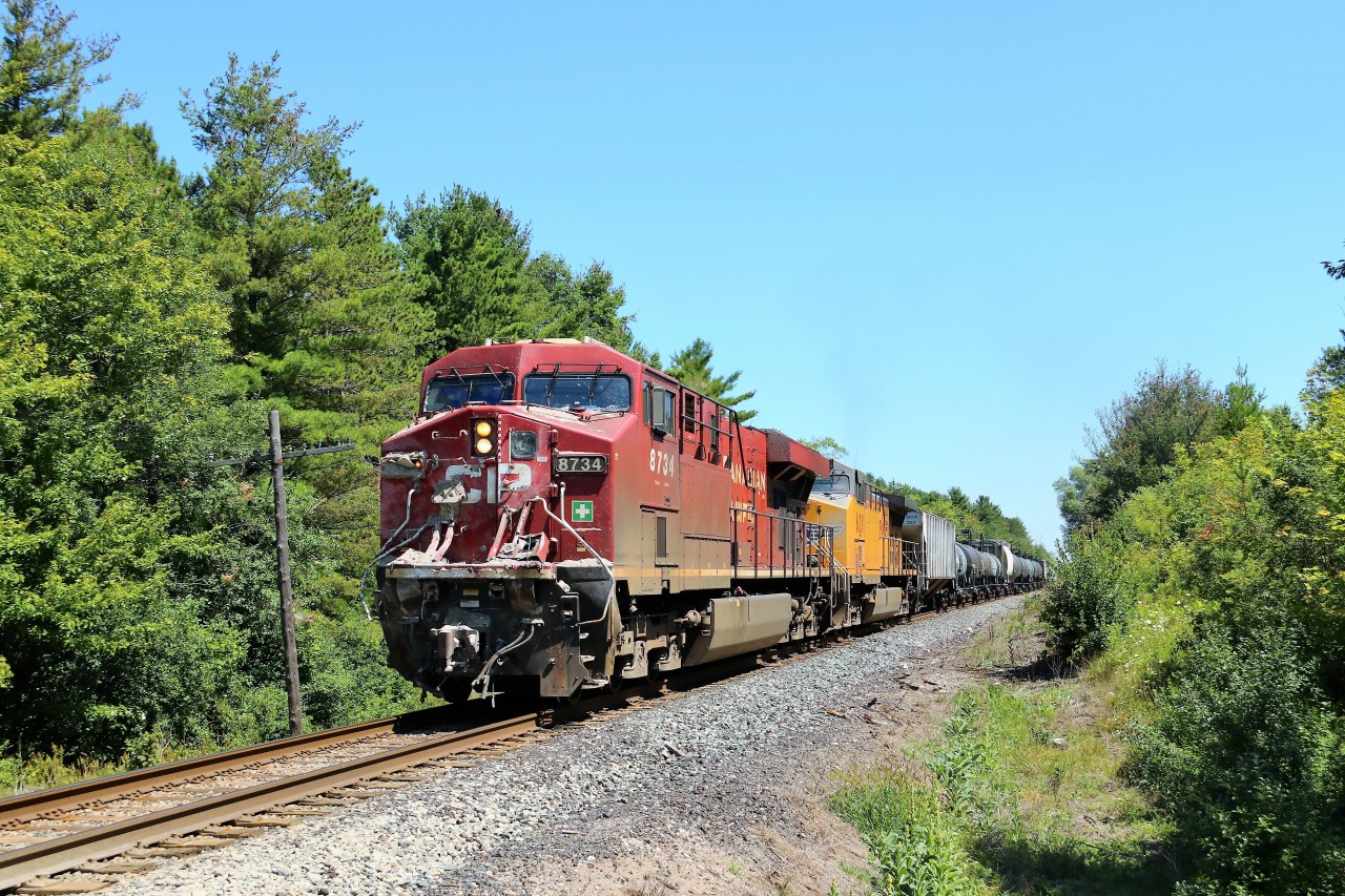 These guys are lucky to be alive! Just a few roads back, CP 235 hit a loaded dump truck at Concession 7 at better than 50 miles per hour. The dump truck ended on its side in the swamp and the driver managed to climb out to safety on the road. Still wearing some of the contents of the truck and with its cow catcher and ditch lights destroyed, they continued on their way to Wolverton. Make note of the buffer car and the tankers of Flammable liquid right behind the engines and this could have been much much worse for everyone.