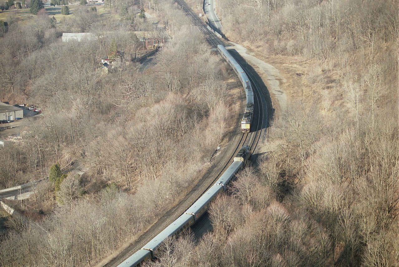 The very fact that VIA #71 was late this particular morning gave me a chance image that was a bit out of the ordinary. From my location on Dundas Peak I was watching the progress of #70, with two units up front, (coming from top to bottom in photo) and almost didn't see #71 entering the picture heading west.
Too far up to catch unit numbers though. The landscape sure looks drab with no snow and a very early sun, as this image was shot around 0910 hrs.
But a neat catch.
These days, in the name of "progress", hanging out at the Peak is not the same as it was. What was once a free hike any old time now revolves around giving money to enjoy..............and it might be noted very few are contributing photos taken from this location as of late.