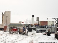 Two trains in Goderich, Ontario - a rare sight that I didn't really understand at the time was quite rare. With the sifto evaporator plant in the background and lots of railway infrastructure there's plenty to look at in this photo. Mother nature was still angry and the flags flying in the wind are a testament to what the boys were up against south of town (lots of drifting!).<br><br> After plowing from Clinton to Goderich, 581 followed the plow into town and the extra will run engines first to Clinton Jct, wye the train then plow back to Stratford where the action was heavy.<br><br> What I find striking is how GEXR seems to have had a large spareboard in this era - running extras regularly including, in the same week of this photo and at the same time two plow extras, one going to/from Goderich and the other to/from London. These were golden days on the GEXR for sure. Dare I say peak GEXR.