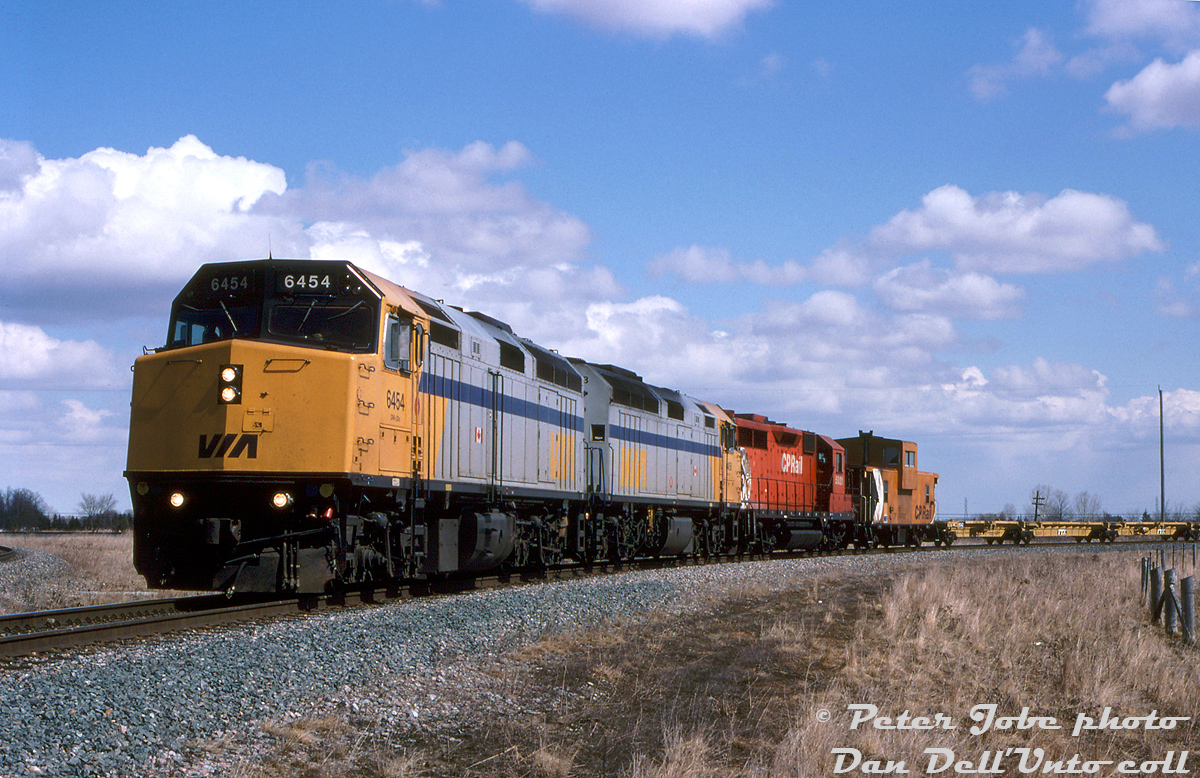 In the early 90's the ever power-short Canadian Pacific Railway at one point had over 180 foreign units leased, and must have been scraping the bottom of the barrel when they knocked on VIA's door to borrow some of their passenger power. The early 90's VIA cuts probably rendered some of their equipment surplus, allowing CP to get their hands on four F40PH-2D units (later increased to eight) to press into freight service during 1994-95, with some swapped in and out with others due to inspections (apparently a few were units due for overhaul, and VIA delayed their overhauls until CP was done running them ragged). The F40's passenger gearing meant they wouldn't pull as much as a normal 3000hp 4-axle freight unit, so they could often be found with a colourful array of leasers and borrowed power (many of the "rent-a-wrecks" were trail-only and not qualified to lead on CP), as well as CP's own army of red units including various Geeps, SD's, MLW 4-axles and a handful of 6-axle big M's that were pulled out of retirement for one last hurrah.Information suggests normal assignments for the VIA F40's were on CP 900-series Toronto-Montreal freights, but they did find their way on local assignments and wayfreight work, including on jobs to Oakville, Niagara Falls, Owen Sound and Havelock. Seen here one afternoon, back-to-back VIA F40PH-2D's 6454 and 6458 lead CP GP35 5021 on what is labeled the "Vaughan Transfer" (probably a transfer run from Obico Yard in Toronto), inbound for the Vaughan Intermodal Terminal as they curve around the south leg of the VIT lead at Elder.The VIA units were likely some of the first leasers to return when CP received their first order of AC4400CW's from GE in 1995, but even when CP was taking on its second order in 1997, motive power assignment sheets still show at least 150 leasers on hand.Peter Jobe photo, Dan Dell'Unto collection slide.