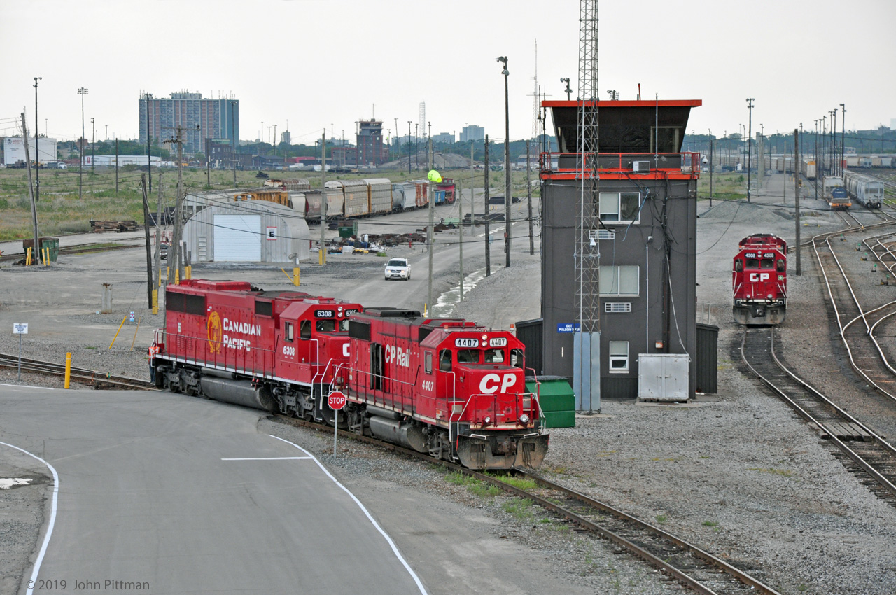 CP's Toronto Yard in Agincourt has a lot less track nowadays. 
This view from Finch Avenue bridge shows beltpack-controlled switching units CP 4407 (GP38-2) and CP 6308 (SD60-3), both of Soo Line heritage, at work below the East Pulldown Tower. 
Note the remains of the hump adjacent to the yard tower in the distance, and the weedy area left of it which formerly held tracks receiving cars off the hump. A CP plow is between the yard towers, last car in siding.