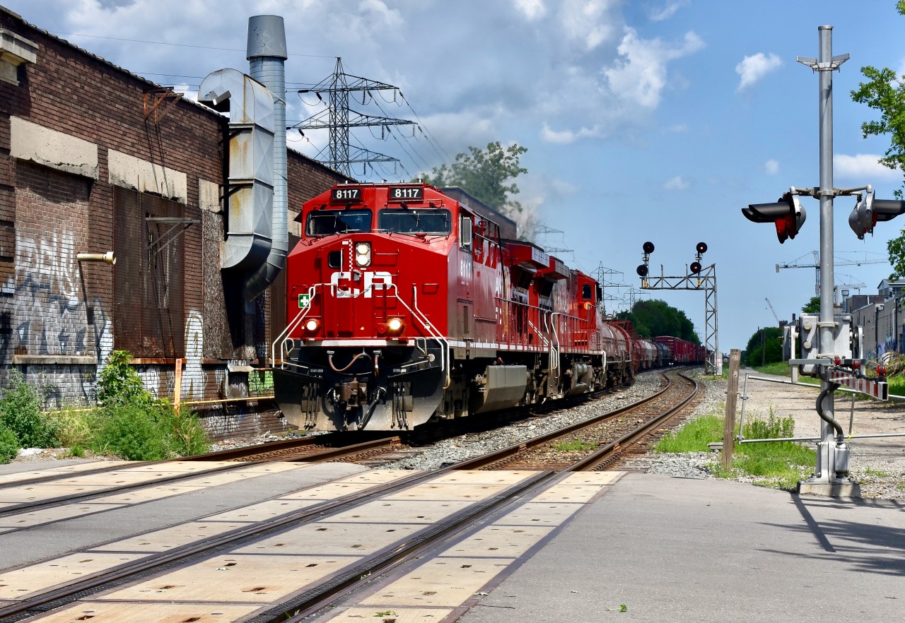 A fine and sunny afternoon in July finds CP ac4400CW 8117 leading a decent sized train 420 manifest through the major city of Toronto as they make their way westward out of the CPR yard and towards the Galt Sub and eventually the USA. Train is about to cross the Bartlett ave downtown crossing and the factory-like building which they are going right by on the left is none other than a typical downtown restaurant/bar, but with the rather unique name known as ‘Blood Brothers Brewing’! I gotta check that place out sometime!! Hopefully will remember to do so on my next visit to the North Toronto Sub! Timing is 14:51