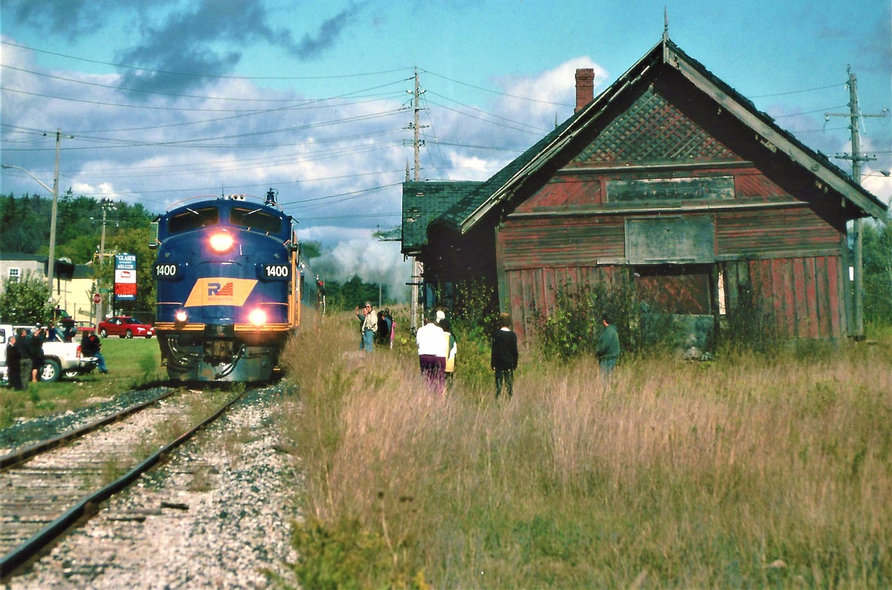 The St. Thomas Central Railway operated by the Southern Ontario Locomotive Restoration Society, ran their former Essex Terminal Railway 0-6-0 #9 on the Goderich-Exeter Railway from September 26 to October 19, 2003. The fall excursion was named the Goderich-Exeter Heritage Steam Tour 2003. The train, complete with several passenger cars and a restored caboose, also had RaiLink FP9u 1400 assisting on the opposite end of the steam engine. The FP9u had recently been sent to the GEXR from Calgary, Alberta. The train toured the GEXR system and visited many cities/towns where steam was last seen decades ago. Thousands of people rode the train over the three-week period and it gave everyone who witnessed the excursion a trip back in time.
The excursion is seen passing by the Hespeler, Ontario train station with FP9u 1400 leading the consist on October 5, 2003. Unfortunately, the historic station was destroyed by a fire less than a month later and was demolished leaving a vacant hole where it once proudly stood.