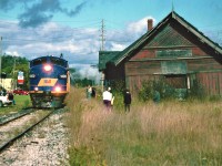 The St. Thomas Central Railway operated by the Southern Ontario Locomotive Restoration Society, ran their former Essex Terminal Railway 0-6-0 #9 on the Goderich-Exeter Railway from September 26 to October 19, 2003. The fall excursion was named the Goderich-Exeter Heritage Steam Tour 2003. The train, complete with several passenger cars and a restored caboose, also had RaiLink FP9u 1400 assisting on the opposite end of the steam engine. The FP9u had recently been sent to the GEXR from Calgary, Alberta. The train toured the GEXR system and visited many cities/towns where steam was last seen decades ago. Thousands of people rode the train over the three-week period and it gave everyone who witnessed the excursion a trip back in time.
The excursion is seen passing by the Hespeler, Ontario train station with FP9u 1400 leading the consist on October 5, 2003. Unfortunately, the historic station was destroyed by a fire less than a month later and was demolished leaving a vacant hole where it once proudly stood. 