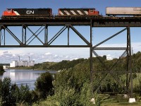 Once again, another shot of the high CN bridge over the North Saskatchewan River. But this is an unconventional view. 
It seems to me that several intermodal train arrived in Edmonton about dinner time. That might be the reason that I did not photograph them very often.
The Edmonton Power plant (owned by the city-run utility) is now gone. I don't know if it used oil or gas. It was not a coal burner.