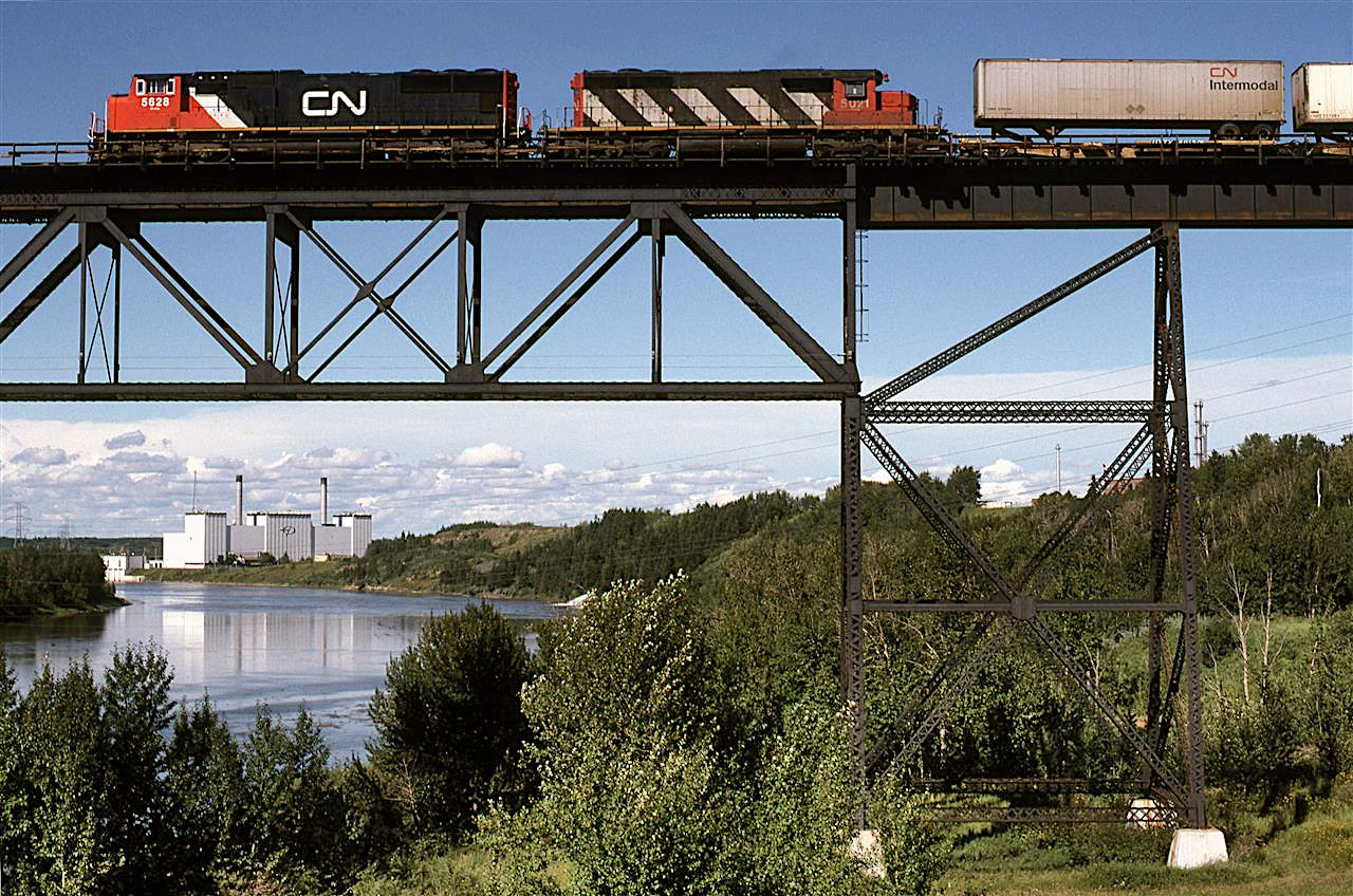 Once again, another shot of the high CN bridge over the North Saskatchewan River. But this is an unconventional view. 
It seems to me that several intermodal train arrived in Edmonton about dinner time. That might be the reason that I did not photograph them very often.
The Edmonton Power plant (owned by the city-run utility) is now gone. I don't know if it used oil or gas. It was not a coal burner.