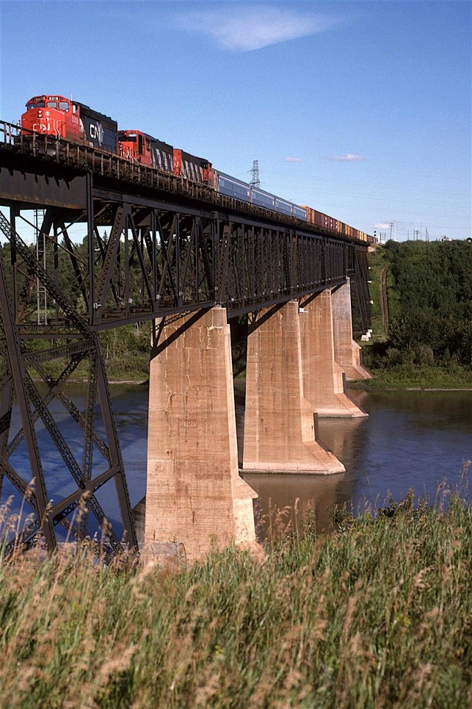 This is the conventional view of the bridge over the North Saskatchewan River in NE Edmonton.
Probably thr mose interesting thing about this photo is the 4 passenger cars in tow. I have no infor about them, however.