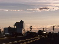 Taken from the site of the former East Junction train station (that handled passenger on the mixed train that came out of Walker yard and went to Fort McMurray), the Clover Transfer is headed out of Walker Yard  on its way to Clover Bar Yard.
The building, at left, is some strange grain handling facility. I don't know if it was active in 1996, but it is no longer there.
