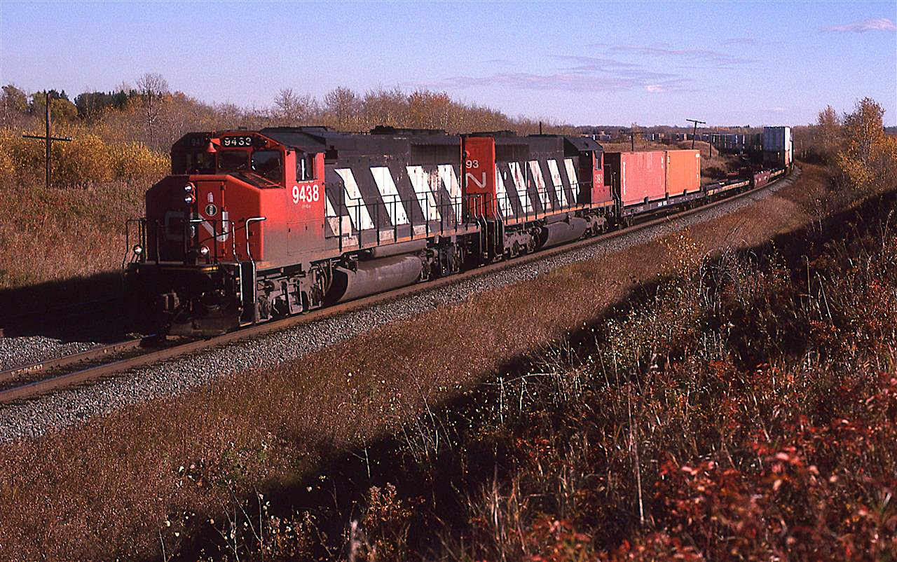 A few strategically placed empty flat cars allow the trailing section of the intermodal train to be seem as it sweeps around the big curve at Bremnar.