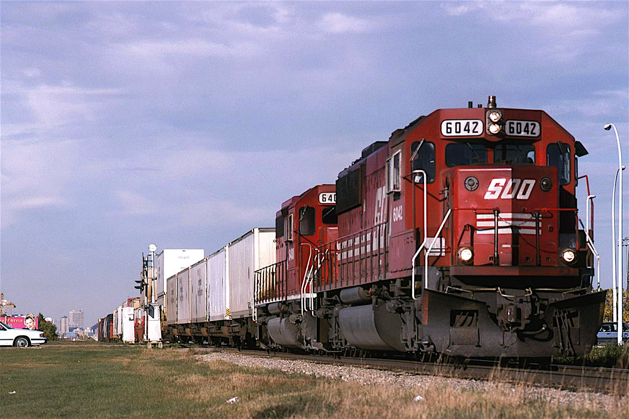 After abandoning the chase down the Camrose Sub, we returned to Edmonton, where my wife took our son into Superstore. Somehow, I knew this train was on its way so I set up in the then empty strip between N Calgary Trail (I think that is what it was called back then, not Gateway Blvd) and the CPR. Note that the Sun is now out.
This is one of only 2 times that I would see a SOO locomotive. The other was on the BN along Sprague Lake in Washington.