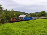 Running as the test train, A406 heads along the countryside of southern New Brunswick, at Norton, with a blue leaser trailing. 