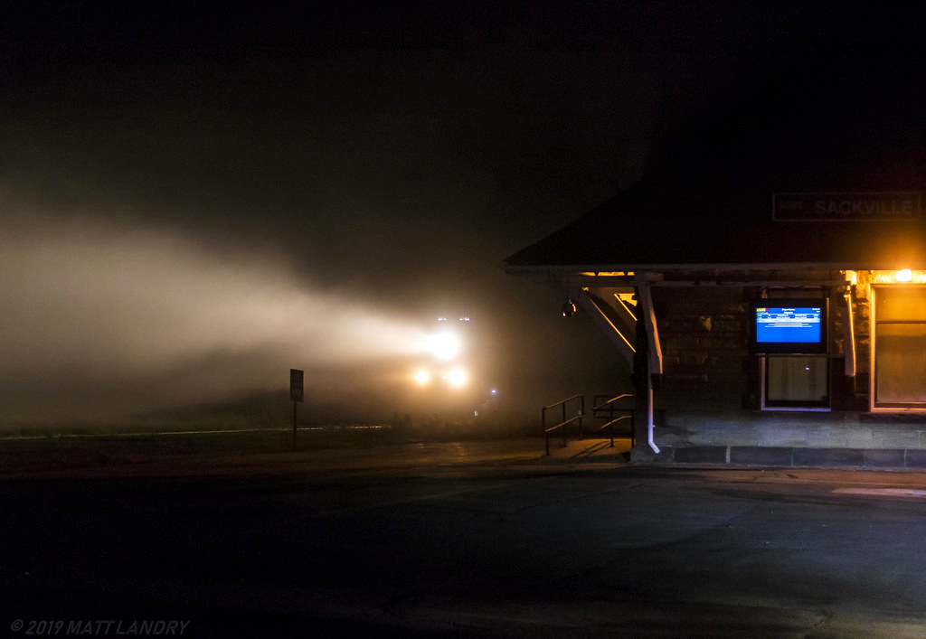 Well before sunrise, an SD70M-2 breaks the silence in the small university town of Sackville, New Brunswick. Seen here, heading by the VIA Rail depot, as they battle last little bit of fog in the area.