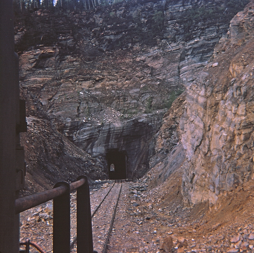 My view heading north on a work train and approaching the short Azouzetta tunnel at mile 598.5. The tunnel at one time had doors on the portal to help prevent icing inside. The doors were protected and opened by a watchman,he inspected the tunnel and then would authorize trains through. This was the only tunnel on the Chetwynd subdivision and after the right of way was re-surveyed the mileage was corrected to mile 597.9. Another Kodak Instamatic Moment from long ago.