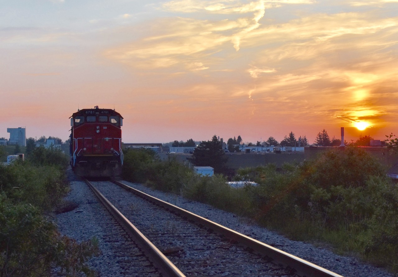 The sun slowly peaks out on what will be a very hot and sunny day in July as CN Local 579 rests at the north end of the 4 mile North Park Spur in Brampton with light power as they await permission to proceed through the busy Brampton Intermodel Yard after having just finished working the Chrysler Assembly Plant. Timing is 05:56am.