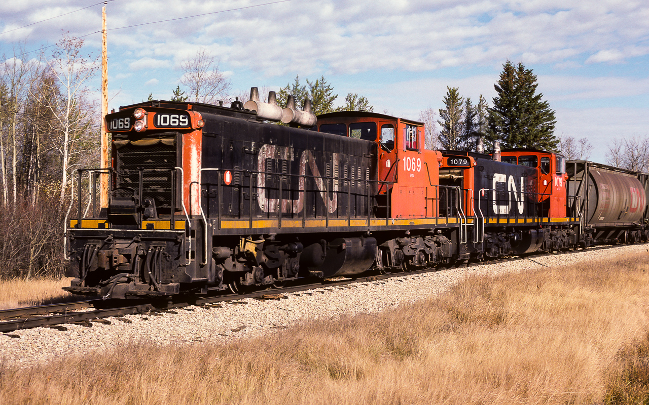 I first saw these engines going through Redwater cabhop with caboose 79669 at 10:30. There was a purpose of sending out 2 light GMD-1's today. Just 2 days earlier, I had watched a huge string of empty CN hoppers, headed for Edmonton, pass through Redwater (powered by GP38's). The hoppers were stored on the abandoned portion of the Lac La Biche Sub., which is accessed at Egremont. To now reach the remaining hoppers, ten hundreds will be needed on the old light rail. Here is the crew at 12:30, a few miles west of Redwater, with the last 65 CN hoppers en-route to Edmonton. It was a big looking train for 2 1000's, but 65 roller bearing empties shouldn't be much of a task. That is the 1079, ex NAR 302 Chief MoosToos, in behind. The new CN paint job still looking pretty fresh.