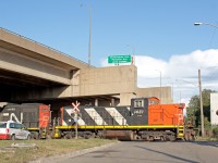 <b><i>Local Access. </i></b>Hamilton can be a confusing place to railfan. If not in the yard at Stuart Street, the multiple jobs can be hard to find among the hundreds of industries. This makes me very thankful that the Hamilton city planners considered this, deciding to put an arrow indicating where the 1600 "Parkdale-Strathearne local" would show up. I parked my car where the arrow pointed and wasn't even 5 minutes later a train showed up. Good value for my tax dollars here... <br><br>CN 1437 and 7046 back there 40+ car train under Nicola Tesla Blvd down towards Stratherne yard. I've heard crews reference this as the Firestone Spur which I'd love to get some background on if anyone has any. American Iron and Metal makes up the majority of the traffic for Stratherne, and dominates rail buisness in this area of the north end. The 1600 job can often bring more the 20 cars for AIM in a single trip, sometimes on all 5 days of the week. AIM itself can have 90 on property, which includes Strathearne yard which AIM has access too. Although the steel production in Hamilton is not what it used to be, places like AIM show how Hamiltons "Steeltown" nickname is still very applicable.