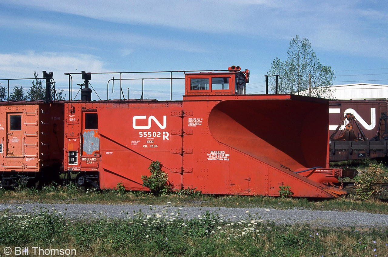 CN snowplow 55502 sits in the yard in Belleville, spending its summer waiting for colder weather and snow to plow. It was built in 1940 as one of CN's few double track plows on the roster, designed with the blade angled to one side to plow snow to one side of the tracks (for double track mainline operations) instead of to both sides like on single track plows. Note the sideways mounted horn (to keep snow out of the bells), old smokejack, and operating/handling instructions on the sides of the plow ("Headlight must be removed before routing this plow through areas with restrictive clearance" and "Warning, this plow is too high to pass through Winnipeg train shed").

55502 doesn't appear on any recent Canadian Trackside Guide rosters, so had likely been disposed of at some point.
