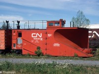 CN snowplow 55502 sits in the yard in Belleville, spending its summer waiting for colder weather and snow to plow. It was built in 1940 as one of CN's few double track plows on the roster, designed with the blade angled to one side to plow snow to one side of the tracks (for double track mainline operations) instead of to both sides like on single track plows. Note the sideways mounted horn (to keep snow out of the bells), old smokejack, and operating/handling instructions on the sides of the plow ("Headlight must be removed before routing this plow through areas with restrictive clearance" and "Warning, this plow is too high to pass through Winnipeg train shed").
<br><br>
55502 doesn't appear on any recent Canadian Trackside Guide rosters, so had likely been disposed of at some point.