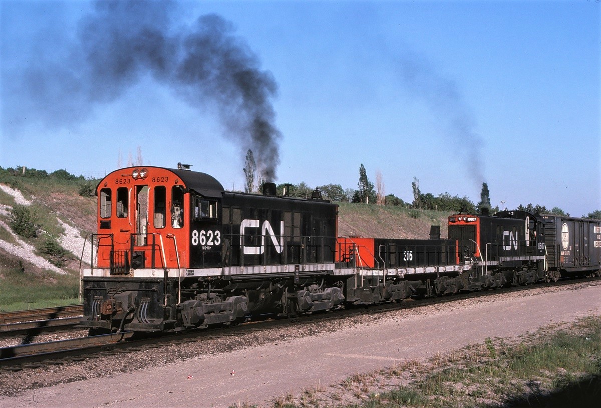 The way it used to be.  MLWs shoving hard to push a long string of cars over the hump at MacMillan Yard (Toronto Yard at the time).  Beautiful sight and sound!!  Units are 8623-305-8607.