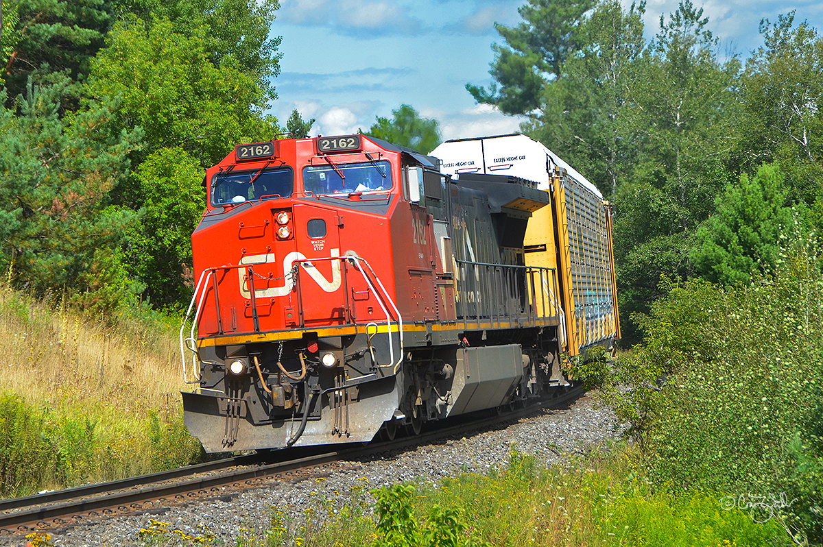 After sitting in 6623-foot Pefferlaw Siding (on the Bala Sub) for a couple of meets, Canadian National Railway train M 31841 (a long haul freight, consisting of all autoracks, heading from Symington Yard in Winnipeg, Manitoba, to MacMillan Yard in Toronto, Ontario) is on the move again as it rounds the curve in Cedar Valley, in Ontario's York Region.  This train warrants just a single locomotive, Canadian National class EF-640g Dash 8-40CW 2162 (the former BNSF 801, originally Santa Fe 801).