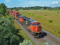 Canadian National Railway intermodal train Q 10851 passes through Newtonville, Ontario, on August 25, 2019.  CN ES44AC 2893 and Dash 8-40CW 2144 (ex-BNSF 818, nee-ATSF 818) are pulling this 10,237-foot train of 135 loads and 20 empties, weighing 8,754 tons, as it makes its way from Vancouver BC to the eastern part of Canada.