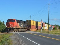 Southbound Canadian National train Q 11251, an intermodal train, passes through Georgina, in Ontario's York District, on August 30, 2019.  This train's journey began about 2775 miles (4466 km) to the west, in Vancouver, British Columbia, and will be over soon as it is only around 55 miles (88 km) away from its final destination of Toronto, Ontario.  CN ET44AC 3055 is up front, with CN ES44AC 3803 helping out in the middle of the train.
