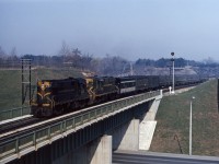 RS18s 3121 and 3116 lead an interesting consist on Toronto-Windsor train No. 75 in the spring of '65. Note the head end cars: an SGU, two express refrigerators, a baggage car plus three different types of coaches (mostly green/black but the "new" CN images is starting to appear). Also note the "Begin CTC" sign next to the high mast signal 006S (which has additional height to improve signal sighting for approaching trains).