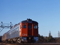 On a fine early summer evening, the "dinner time" train for Niagara Falls rolls through Bayview with two "Budd cars" sporting the new image. However, if you look closely, you can still see "Canadian National" lettering above the windows and will notice that there is no black stripe typical of later repaints. (Several RDCs remained in this variant of the paint scheme into the mid-1970s.)

Also of interest is the new signal cantilever being installed with Centralized Traffic Control over to Burlington and up the Halton sub to the new Toronto Yard. (The 1957 CTC installation only controlled Bayview, Hamilton Jct, Hamilton West, Hamilton Yard and N&NW Jct.)