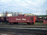 Canadian Pacific flanger 400404 is seen amid other freight equipment in the yard in London in 1966. Like CN, CP also had their own flanger cars stationed around the system for clearing snow and ice from the flangeways between rails.
<br><br>
Like many other flangers CP had, this car had been converted from one of CP's fleet of steel "minibox" boxcars originally built in 1929/1930 (that were shorter in height than most regular steel boxcars). As newer larger boxcars displaced them, many miniboxes migrated into maintenance of way service, including becoming tool cars, bunk cars, flangers, and generator cars. On this car, twin flanger blades have been mounted behind each of the trucks, a cupola added to the roof, access doors cut into the sides, and the old center 5' sliding door has been removed and opening covered over to match the rest of the body.