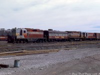 This late 60's three-builder lashup is a nice show of the variety of power CP was running back then. CP steam generator-equipped GP9 8520, F7B 4446, C424 4228 and H16-44 8725 are seen together with a lone 40' boxcar at Alyth Yard in Calgary, noted as assigned to train #987. A much more modern 6-axle mainline unit, SD40 5542, is also visible at the diesel shop in the background. Multiple-unit (MU) standardization in the mid-1950's ensured different models from different builders could all operate together as one in a consist, with some oddball exceptions like Baldwins that featured an air-operated (pneumatic) throttle system.<br><br>CP's motive power policy was to assign blocks of units to certain shop locations for maintenance purposes, especially in the case of oddballs like the CLC and Baldwin fleets, to standardized on things like maintenance and parts on hand. Railfans often note the common saying of "CLC and GMD units in the west and MLWs in the east", but mainline units did stray. A 1970 motive power assignment sheet shows the MLW C424's were assigned to St. Luc for maintenance purposes, but they were common on transcontinental mainline runs early in their lives so could be found out west. Most of the GMD GP7/9's, F7B's and FP7's were assigned to Winnipeg and Alyth for maintenance purposes, but the F's were regulars in the east (less so the GP7/9's, which were better utilized on branchline and roadswitcher assignments out of their home terminals. MLW RS3/10/18's filled that role out east). The H16-44's and much of the opposed-piston FM/CLC fleet were assigned either Alyth or Nelson, and tended to stay on home territory. The GMD SD40's were assigned Alyth, originally purchased for coal service but found to have reliability issues that CP wasn't satisfied with (which was one reason they turned to MLW M630's for Locotrol coal service).<br><br>Small switcher units from both GMD and Alco/MLW such as SW8/900, SW1200RS and MLW S2/S3/S4 models could be found across the system assigned to various terminals and locations for local work, often the same regular units for years on end. And of course, CP's small fleet of Baldwins stayed in the far west (assigned to Vancouver & Victoria). For major overhaul work, wreck-rebuilds and such, all power typically headed to one of CP's two heavy backshops for work: Ogden Shops (Calgary) or Angus Shops (Montreal).<br><br><i>Doug Wingfield photo, Dan Dell'Unto collection slide.</i>