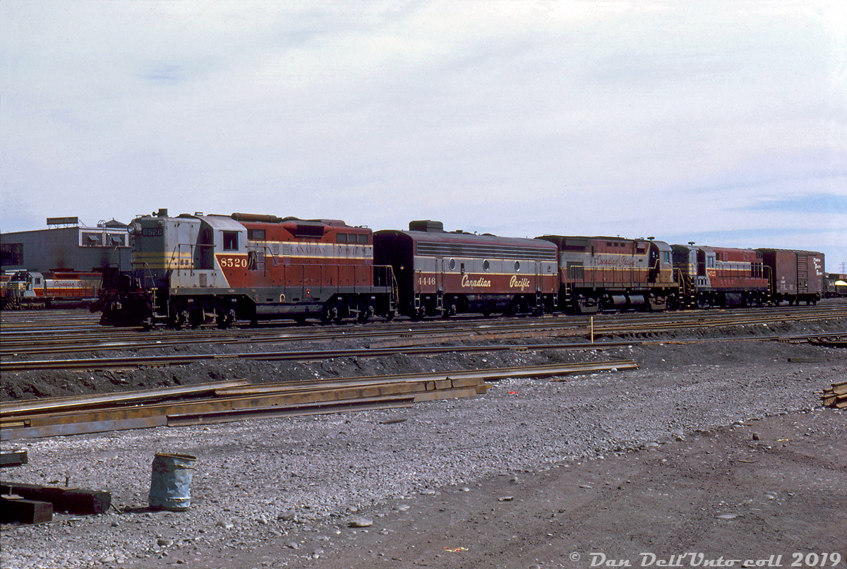 This late 60's three-builder lashup is a nice show of the variety of power CP was running back then. CP steam generator-equipped GP9 8520, F7B 4446, C424 4228 and H16-44 8725 are seen together with a lone 40' boxcar at Alyth Yard in Calgary, noted as assigned to train #987. A much more modern 6-axle mainline unit, SD40 5542, is also visible at the diesel shop in the background. Multiple-unit (MU) standardization in the mid-1950's ensured different models from different builders could all operate together as one in a consist, with some oddball exceptions like CP's Baldwins.CP's motive power policy was (and still is) to assign blocks of units to certain shop locations for maintenance purposes, especially in the case of oddballs like the CLC and Baldwin fleets, to standardized on things like maintenance and parts on hand. Railfans often note the common saying of "CLC and GMD units in the west and MLWs in the east", but mainline units did stray. A 1970 motive power assignment sheet shows the MLW C424's were assigned to St. Luc for maintenance purposes, but they were common on transcontinental mainline runs early in their lives so could be found out west. Most of the GMD GP7/9's, F7B's and FP7's were assigned to Winnipeg and Alyth for maintenance purposes, but the F's were regulars in the east (less so the GP7/9's, which were better utilized on branchline and roadswitcher assignments out of their home terminals. MLW RS3/10/18's filled that role out east). The H16-44's and much of the opposed-piston FM/CLC fleet were assigned either Alyth or Nelson, and tended to stay on home territory. The GMD SD40's were assigned Alyth, originally purchased for coal service but found to have reliability issues that CP wasn't satisfied with (which was one reason they turned to MLW M630's for Locotrol coal service).Small switcher units from both GMD and Alco/MLW such as SW8/900, SW1200RS and MLW S2/S3/S4 models could be found across the system assigned to various terminals and locations for local work, often the same regular units for years on end. And of course, CP's small fleet of Baldwins stayed in the far west (assigned to Vancouver & Victoria). For major overhaul work, wreck-rebuilds and such, all power typically headed to one of CP's two heavy backshops for work: Ogden Shops (Calgary) or Angus Shops (Montreal).Doug Wingfield photo, Dan Dell'Unto collection slide.