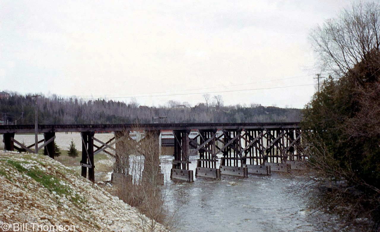 The 1907-built wooden trestle carrying CP's Walkerton Sub across the Saugeen River in Durham is pictured in 1966. Located at about Mile 16 of CP's Walkerton Sub, the line was abandoned by CP in 1984 but the old wooden trestle survives today as the Heritage Walkway Bridge, and recently underwent a half a million dollar refurbishment.