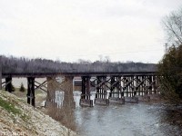 The 1907-built wooden trestle carrying CP's Walkerton Sub across the Saugeen River in Durham is pictured in 1966. Located at about Mile 16 of CP's Walkerton Sub, the line was abandoned by CP in 1984 but the old wooden trestle survives today as the <a href=https://www.southgreynews.ca/local-news/new-life-for-heritage-walkway-bridge><b>Heritage Walkway Bridge</b></a>, and recently underwent a half a million dollar refurbishment.