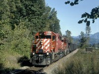 CP 5804 with the 5890 trailing, are about to enter the westward track tunnel with a loaded coal train at Agassiz, on CP's Cascade Sub. With two tunnels side by side at this location, the other track visible in the background was, before directional running began, for eastbound traffic only. 