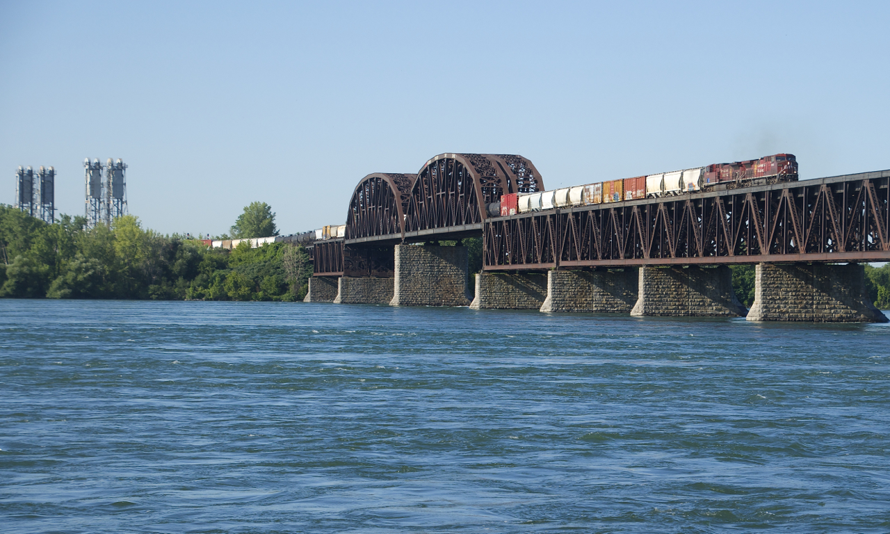 CP 253 with CP 8505 & CP 8626 for power and a long train crosses the St. Lawrence Seaway and River after being delayed by a boat.