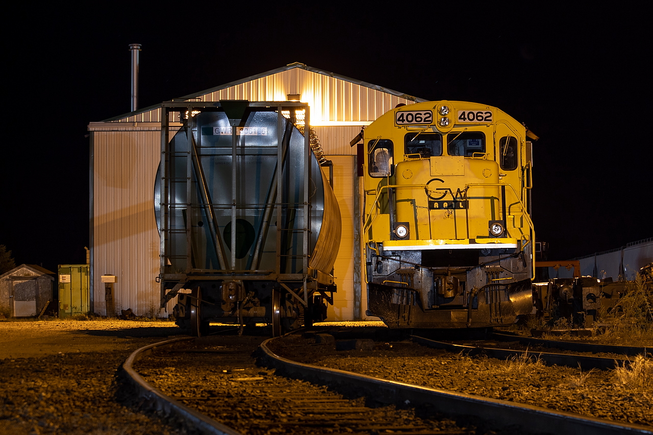 After a really windy couple of days in the Assiniboia area, things calmed down a lot at night on my second night there. I was quite grateful for this as I was hoping to do night shots and was worried about camera shake otherwise. There was power kicking around near the shop more often than not from what I gathered, so knew my time here would present one of the better opportunities on my trip for night shots. On the shop tracks for the GWR on this particular night was 4062, as well as one of their purchased hoppers from the Saskatchewan fleet. The previous morning I'd watched them waste no time working on bad order cars. Within 15 minutes of a hopper going on the shop track they had it hoisted and work was underway. An impressive and friendly operation. Photo taken with permission.