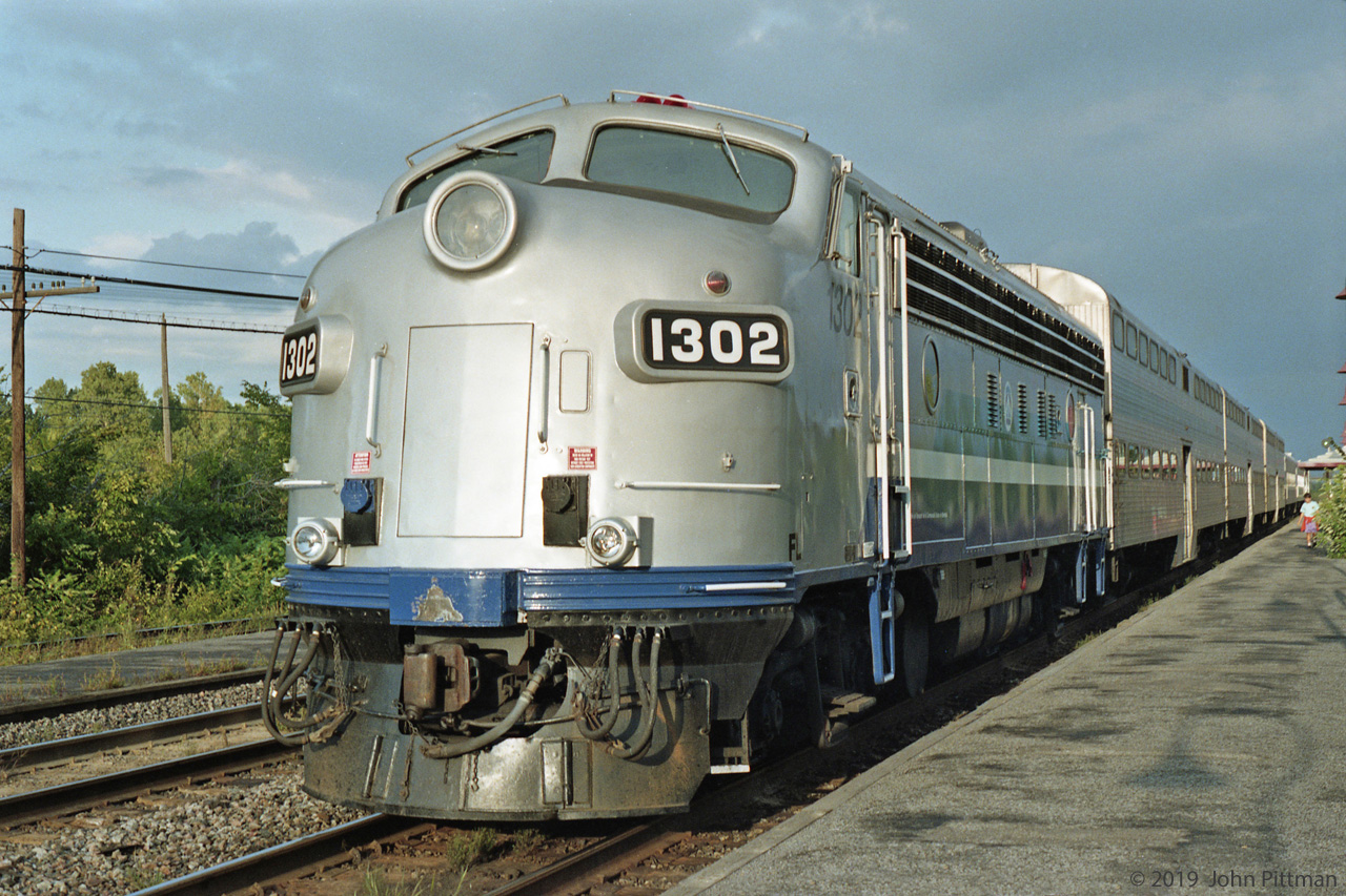Ex-CP FP7A MUTC 1302, pushing a commuter train of 3 bilevel gallery coaches and at least 2 single-levels, has stopped for passengers at Beaconsfield Station. The train has a green signal to continue east to Montreal.
This FP7A was originally CP 4072, next CP 1428, then CP 4072 again. CP F-unit cabs did not have front MU, but it's been added.
At the time the name on the equipment was "Société de Transport de la Communauté Urbaine de Montréal". 
We ended our round-trip excursion here - the westward part was cut short because the ticket inspector (conductor?) advised us that the last chance of returning that day was to catch this eastbound.