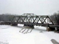 The steel swing bridge carrying Penn Central's CASO Sub (ex-Michigan Central) over the Welland River at Montrose is pictured, as viewed from the nearby Queen Elizabeth Way on a gloomy day in 1967.
<br><br>
At the time of this photo, this portion of the CASO ran straight from Niagara Falls to Welland. Due to the Welland By-Pass project, it wouldn't be long before a portion of the line to the west was diverted south on a new alignment via Brookfield to the new Townline Tunnel running under the Welland Canal. This bridge and portion of the line still see rail traffic today (but far less volume), as this part of the CASO became CP's Hamilton Sub in the 1980's, and later CP's Montrose Sub.