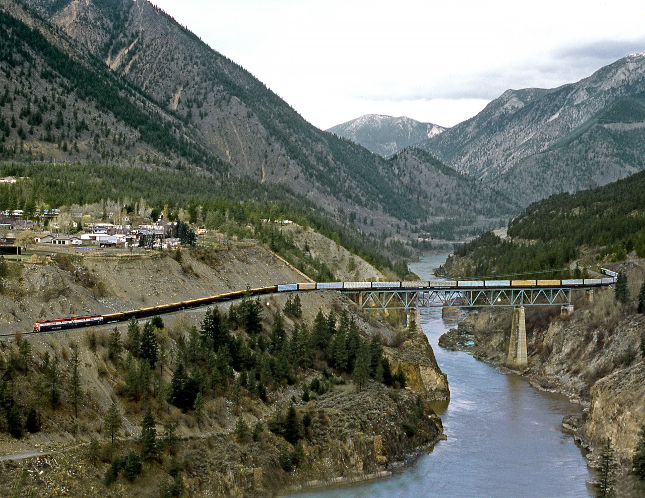 Southbound P-V(Peace-Vancouver) crosses the Fraser River about 2 miles north of the Crew Point at Lillooet. The train has just descended the Fraser Canyon on 20 miles of 2% grade from Kelly Lake