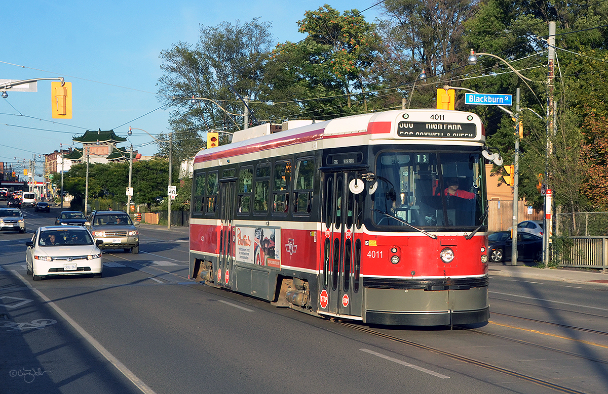 Toronto Transit Commission CLRV 4011 heads west on the TTC's 506 Carlton line, passing through the intersection of Gerrard and Blackburn.  These Canadian Light Rail Vehicles were constructed by Bombardier-predecessor Urban Transportation Development Corporation (UTDC) from 1978 through 1981, and were unique to the city of Toronto, Ontario.  After nearly 40 years of service (beginning on September 30, 1979), the CLRVs will be retired by the end of 2019, replaced by more modern streetcars.  In the background is the Zhong Hua Men (中华门 or 中華門) Chinese Archway in the city's East Chinatown district.  The archway, which officially opened on September 12, 2009, was built to commemorate Canada's Chinese pioneers, labourers, railway workers and subsequent descendants and immigrants of Chinese descent who contributed to all aspects of Canadian society.  (August 30, 2019)