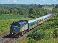 Leading four LRC cars and a stainless steel coach, VIA Rail Canada F40PH-3 6412 and its train (VIA 643, a weekend service Corridor train heading from the capital of Ottowa to Toronto) passes through Newtonville, Ontario, on August 25, 2019.