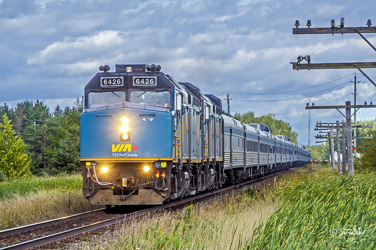 VIA Rail Canada train 2, the eastbound Canadian, speeds through Georgina, in Ontario's York District, on August 30, 2019.  This train originated in Vancouver, British Columbia, and has about 88 km (55 miles) left in its 4466 km (2775 miles), five-day and four-night journey to Toronto ON.  VIA F40PH-3s 6426 and 6435 are hustling their 21-car train at about 128 km/h (80 mph) as they click off the final miles of this longest passenger train route in Canada.