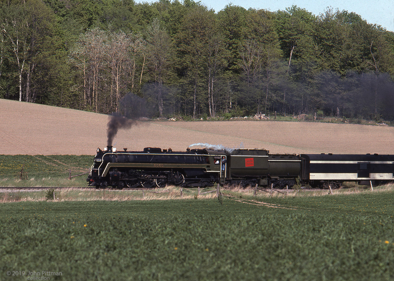4-8-2 steam engine CN 6060 leads passenger equipment near Glen Robertson Ontario in this image processed May 1977. Twenty U-1-f class "Bullet Nose Betty" locomotives CN 6060-6079 were built by MLW between October 1944 and January 1945.
Glen Robertson is about 4 km west of the Ontario-Quebec border, between the Ottawa and St Lawrence Rivers.  The baggage coach number appears to be 9623, though CN also had a GP40-2L(W) with this number.
