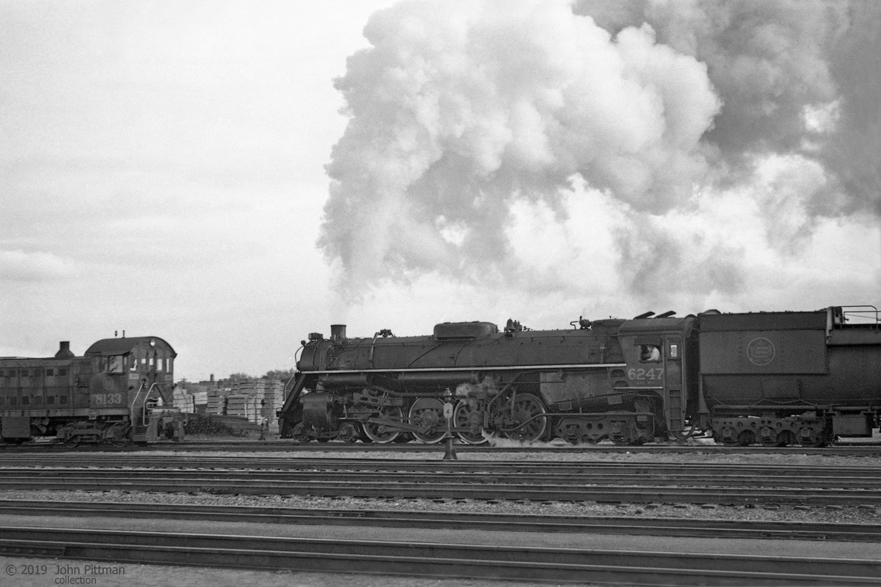 4-8-4 "Northern" CN 6247 appears to be working hard at low speed, with a crewman watching the front left from his cab window. 
The engine and train are about to pass MLW S-2 switcher CN 8133, class MS-10a built in 1949.
CN 6247 was built by MLW in Sept 1943, CN class U-2-h. It was scrapped in July 1961.

The negative data indicated location Danforth, presumably on the 3 km section of CN's Kingston sub that runs within 200 meters of Danforth Ave in Scarborough (Toronto).  CN Danforth is about 5 rail miles east of Toronto Union station, while GO Transit Danforth Station is at Main St.