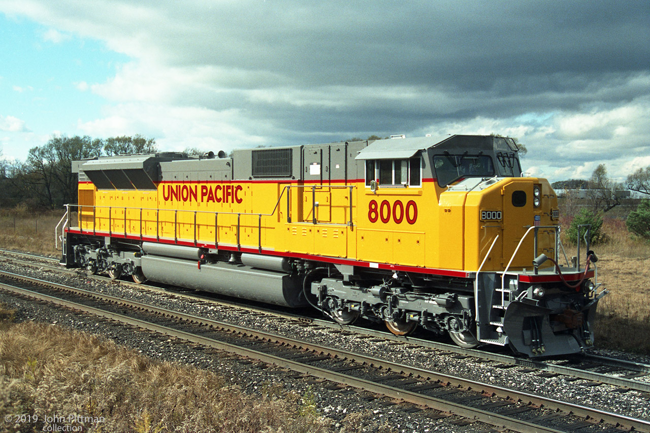 UP 8000 was the first production SD90MAC, with the well-proven 4300 HP EMD V16 710G3B 2-stroke diesel engine installed "temporarily" until such time as the intended 6000 HP EMD GM16V265 4-stroke diesel was sufficiently developed. It is seen here on the GMDD test track beside CP's Galt Subdivision. 
The 265-H engine had far more problems than anticipated, so over 400 more SD90MAC locomotives were built with the 710G3B engine, becoming known as "SD9043MAC". Original customers were UP, CP, and CEFX.  
None of the SD9043MAC units were ever converted to the 6000 HP engine by a railroad, because production SD90MAC-H locomotives with the 265-H engine were so unsuccessful.
Over 100 ex-UP and ex-CEFX SD9043MAC locomotives have been remanufactured to SD70ACU for Norfolk Southern.  Canadian Pacific is getting the same thing done with their SD9043MAC fleet.