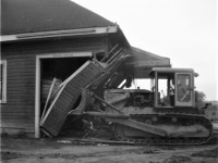 On the morning of Tuesday, August 31st, 1965, after westbound freight 401 passed, crews went to work to erase the old wood frame CN Pembroke Ontario station from the planet. The west wall of the building was the first to go.  This photograph shows one of the first blows being administered. As the entire structure was deemed as scrap, no effort was made to save anything. The process took only about a hour. Location is approximate. 