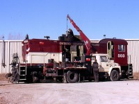 On this date the new OSR shop in Guelph Jct was still new and lacked lighting and a pit so most maintenance of locomotives was still done outside. In this case the workers needed a small crane as it appears OSRX 503 was having a cylinder changed out. 