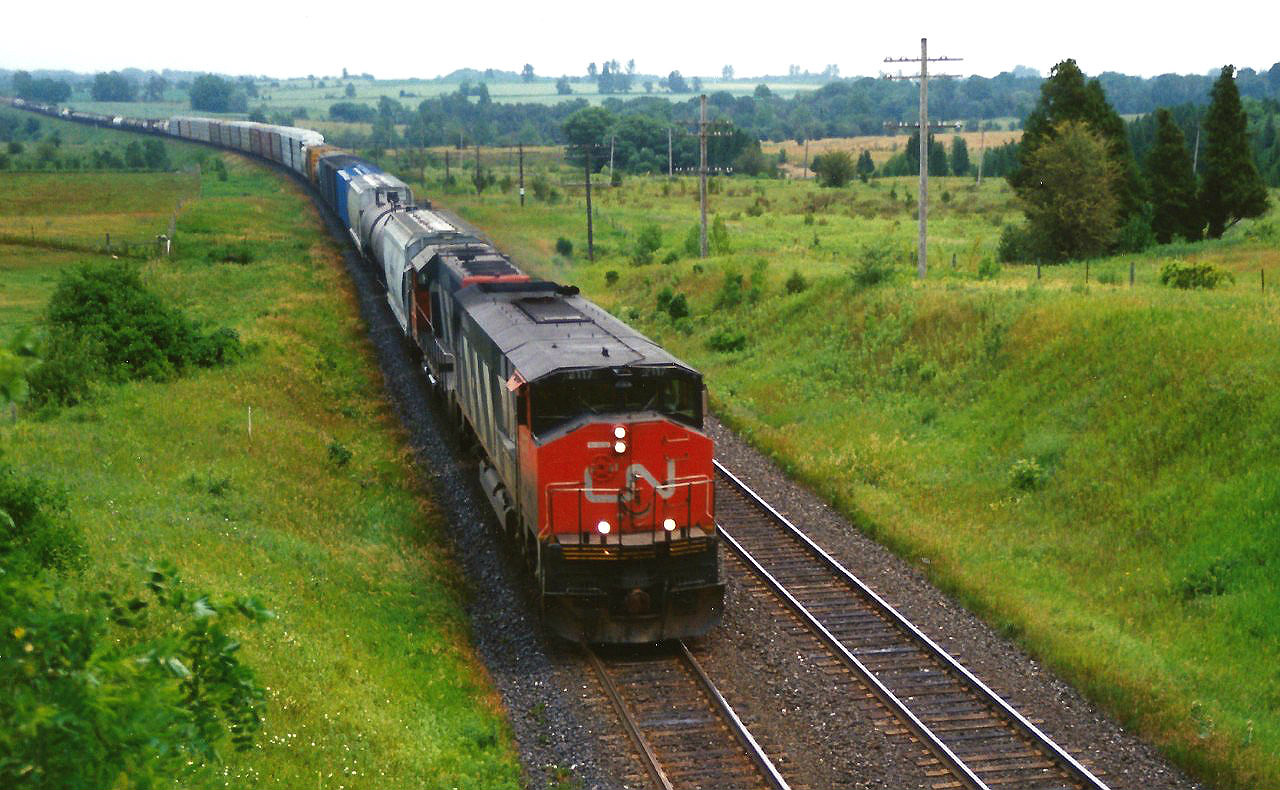 CN HR616 2117 is seen leading a westbound train through the sweeping curve at Newtonville, Ontario on July 15, 1994. CN 2117 would be retired three years later in 1997 and the all the remaining active HR616’s were retired during 1998.