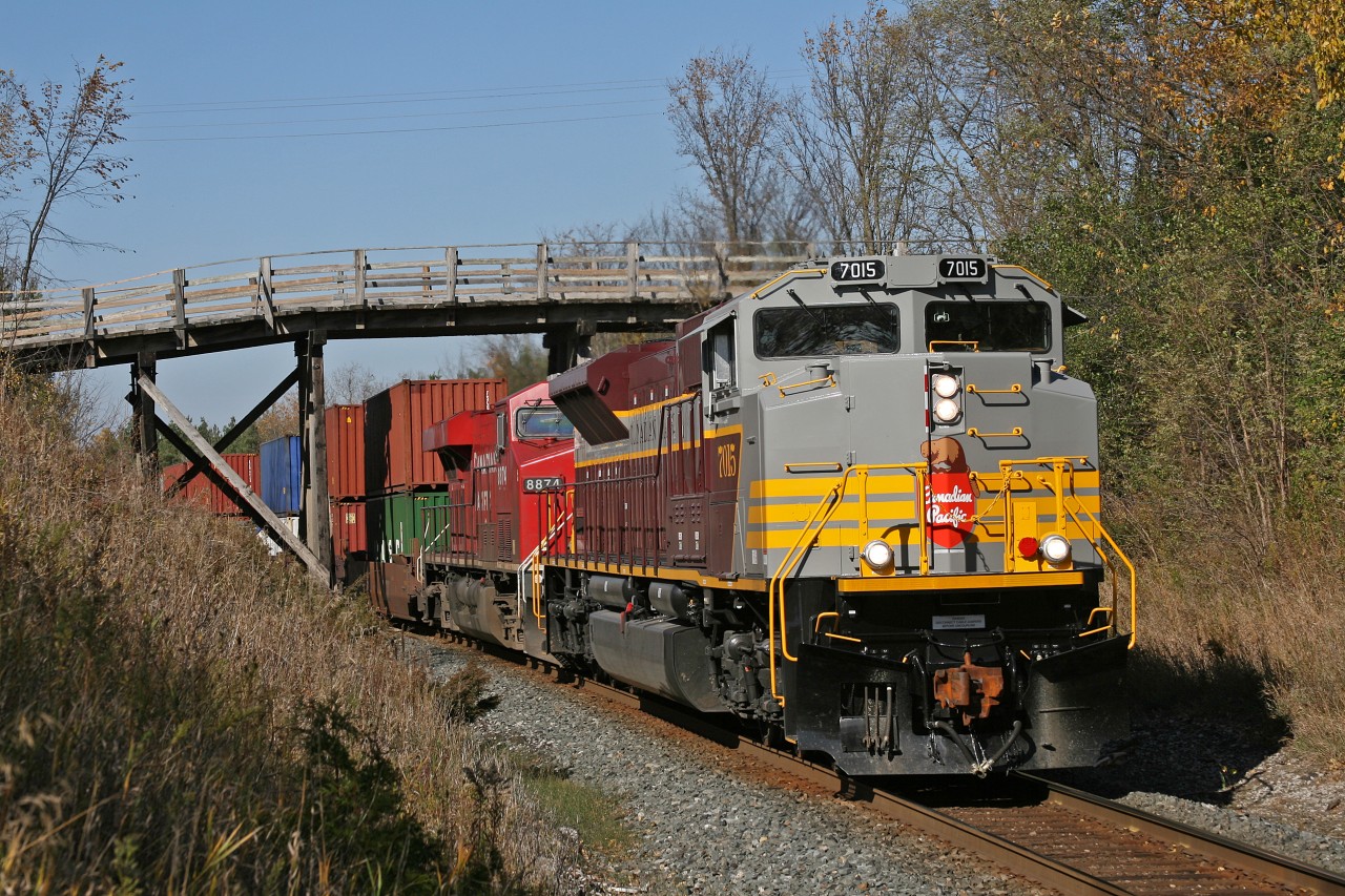 CP 100-24 eases under the wooden bridge just north of Tottenham, with CP 7015 sporting the classic Maroon & Grey Canadian Pacific livery.