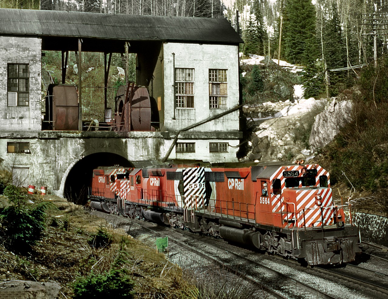 A westbound exits Connaught tunnel at the summit of Rogers Pass. Today this line only sees eastbounds with westbounds using the 1986 constructed Mount MacDonald line